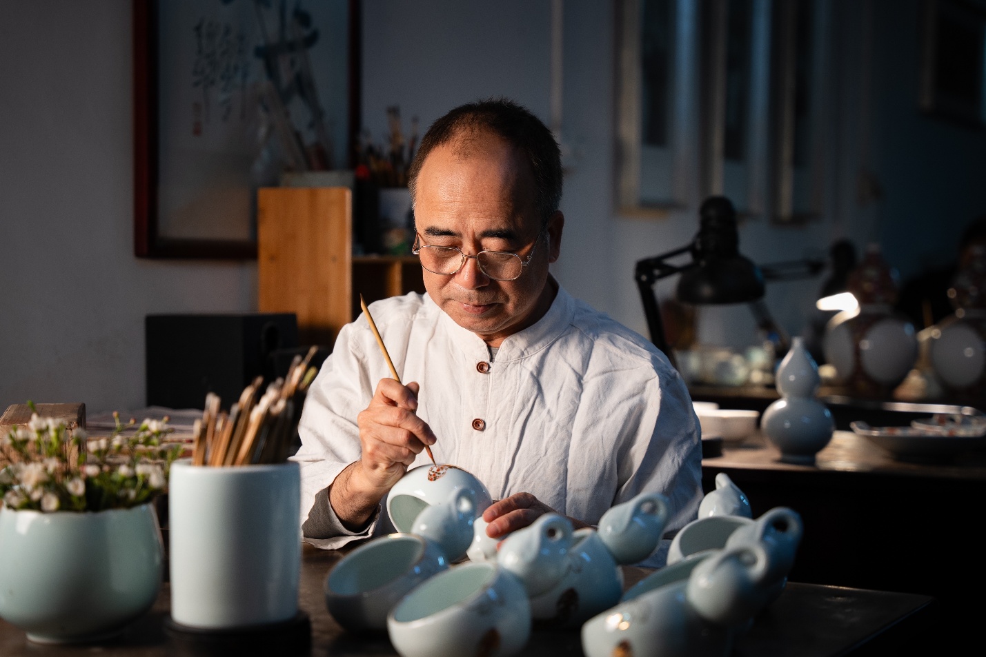 A person painting a cup

Description automatically generated